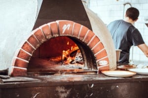A brick pizza oven with fire inside