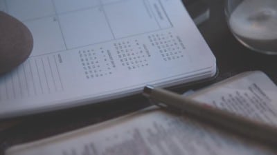 pen resting on paper calendar