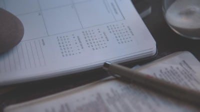 pen on paper calendar – check the dates pen resting on paper calendar