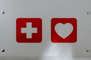 a white wall with a white safety cross and white heart surrounded by red