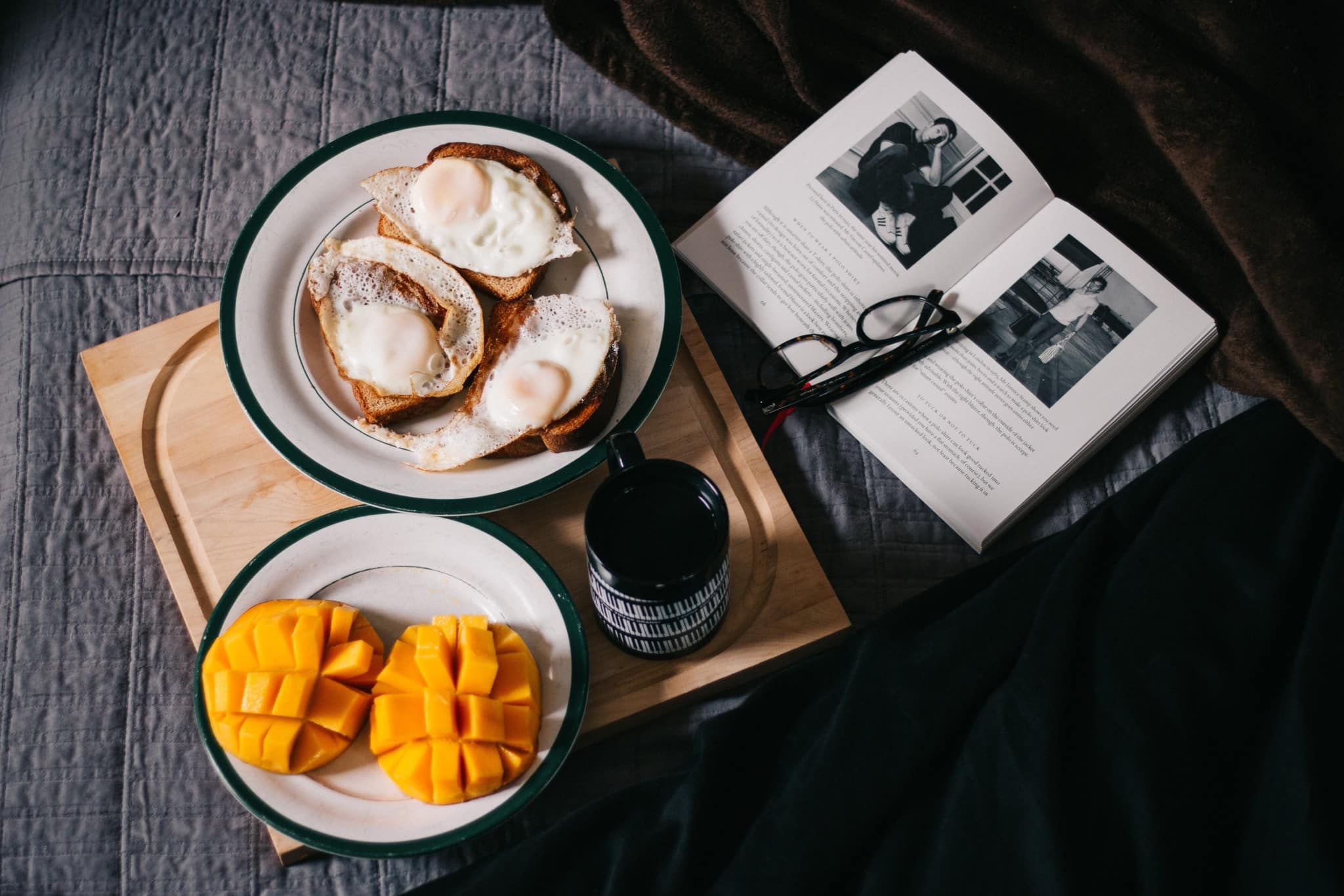 sliced mangos, eggs, and bread on bed